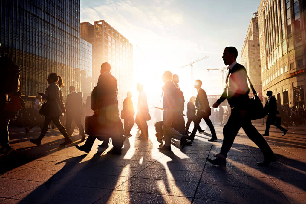 Business professionals walking through a city at sunrise, symbolizing adaptation and growth amid tax tariffs and economic change.